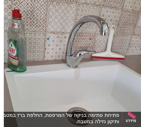 כיור מטבח עם ברז וכלי ניקוי